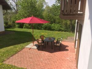 a table and chairs with a red umbrella on a brick patio at Holiday Home in Javorník near Krkonose Park in Rudník