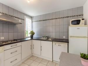 Una cocina con gabinetes blancos y un refrigerador blanco. en Cozy Hillside Escape in Berre, en Berre-des-Alpes