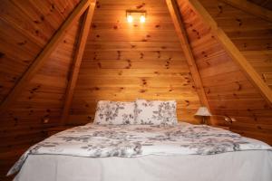 a bed in a room with a wooden ceiling at Škrka cotege - center of Zabljak in Žabljak