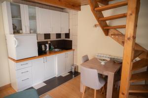 a kitchen with white cabinets and a wooden table at Škrka cotege - center of Zabljak in Žabljak