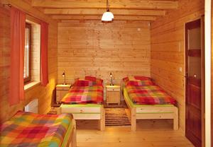 um quarto com 2 camas num chalé de madeira em Chata Iľanovka em Demanovska Dolina