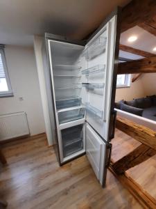 an empty refrigerator with its door open in a room at Ferienwohnung Bauernhaus 2 in Balingen
