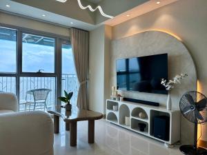 Una sala de estar con televisión y un sofá. en Panoramic Seaview near Airport Facing the Bay 14H, en Manila