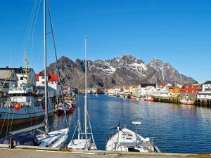 a group of boats docked in a harbor with mountains at 3 person holiday home in Henningsvær-By Traum in Henningsvær