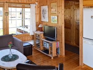 a living room with a television and a table at 3 person holiday home in Henningsvær in Henningsvær +12 photos