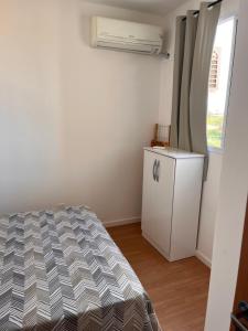 a bedroom with a bed and a dresser and a window at Ap em ótima localização in Cuiabá