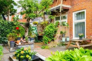 a patio with a table and a building with plants at Cessinas in Groningen