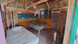 Guna Yala alojamiento frente al mar Niadub في Cagantupo: غرفة صغيرة مع سرير وسيدكس سيكس