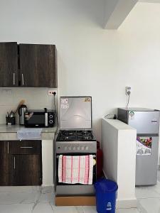 a kitchen with a stove and a refrigerator at Saka Homes, Cozy 1-BR Bamburi in Mombasa
