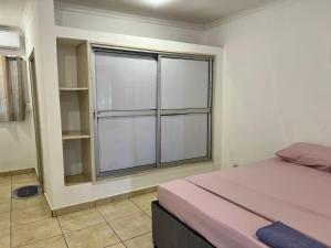 a bedroom with a bed and a large window at Legacy accommodation in Vila-de-Santiago-Maior