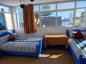 a living room with two blue couches and a table at مقهى المدينة احبك in Asilah