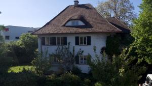 an old white house with a brown roof at Zentraler Charme im historischen Dachgeschoss in Bregenz