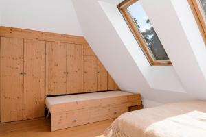 a attic bedroom with a bed and a window at Zentraler Charme im historischen Dachgeschoss in Bregenz