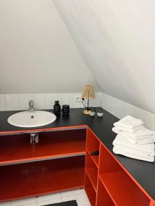 a bathroom with a sink and a black counter at Zentraler Charme im historischen Dachgeschoss in Bregenz