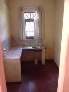 Habitación pequeña con lavabo y ventana en Alahakoon Guest house, en Polonnaruwa
