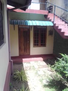 una pequeña casa con puerta y porche en Alahakoon Guest house, en Polonnaruwa