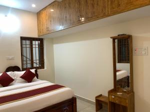 a bedroom with a bed and a mirror at Shivalaya Rooms in Tiruvannāmalai