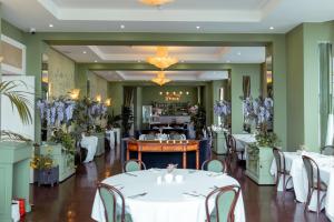 a restaurant with white tables and chairs and purple flowers at The Chatsworth Hotel in Eastbourne