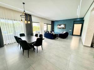 a living room with a dining room table and chairs at Villa exclusive Ourika piscine sans vis-à-vis in Segraga