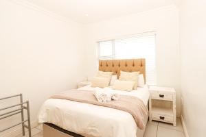 een slaapkamer met een bed met witte lakens en een raam bij Queens View 33 in Margate