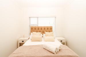 een slaapkamer met een groot bed met witte muren bij Queens View 33 in Margate +3 foto's