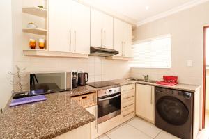 een keuken met witte kasten en een vaatwasser bij Queens View 33 in Margate