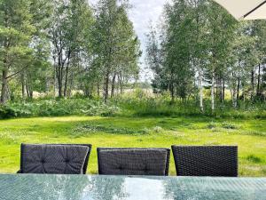 a glass table with two chairs and a field at 10 person holiday home in KATTHAMMARSVIK in Katthammarsvik