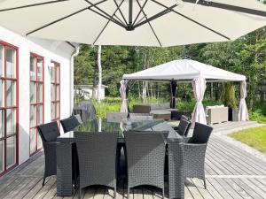 a table and chairs with an umbrella on a deck at 10 person holiday home in KATTHAMMARSVIK in Katthammarsvik