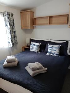 a bedroom with a bed with towels on it at Lapwing Lodge, Howdales in Louth