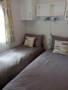two beds sitting next to each other in a room at Lapwing Lodge, Howdales in Louth