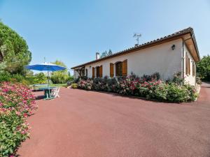 a house with a bench and an umbrella and flowers at Dordogne Villa River Bliss in Pineuilh +32 photos