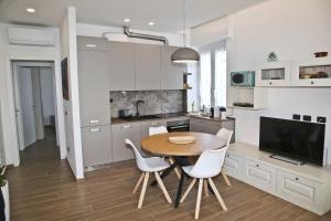 a kitchen with a wooden table and white chairs at Da Santa - Center, Fiera Rho, Malpensa, Milan, Laghi in Legnano