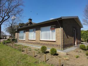 a brown brick house with white windows on a field at Holiday Home Koewacht near Seaside in Nieuwemolen