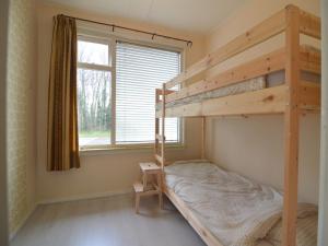 a bedroom with two bunk beds and a window at Holiday Home Koewacht near Seaside in Nieuwemolen