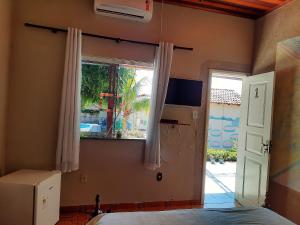 a bedroom with a bed and a window and a door at Hospedagem Serra da Lua in Alter do Chao