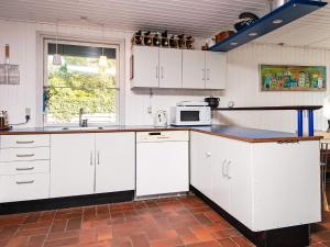 a kitchen with white cabinets and a microwave at Cozy Beach House - By Traum Ferienwohnungen in Fjellerup Strand