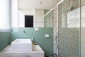 a bathroom with a sink and a shower at Seu Refúgio em Santos, Pé na Areia in Santos +31 photos