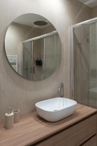 a bathroom with a white sink and a mirror at Cálida apartments in Cefalù +24 photos