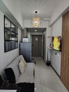 un soggiorno con un divano e una televisione di CozyStay by MA Condotel-Coast Residences a Manila