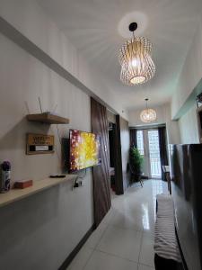 un soggiorno con una TV a schermo piatto su una parete di CozyStay by MA Condotel-Coast Residences a Manila