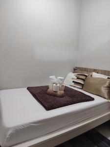 un letto bianco con due tazze sopra di CozyStay by MA Condotel-Coast Residences a Manila Altre 20 foto