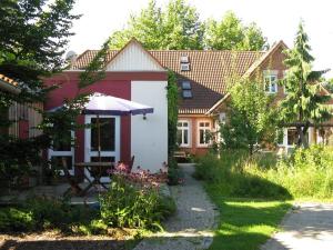 a house with a table and an umbrella in the yard at Ferienwohnungen Wildblume in Winsen Aller