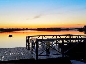 a dock on a lake with the sunset in the background at 4 person holiday home in Väckelsång in Väckelsång