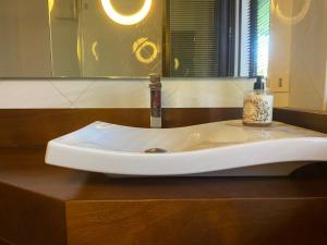 un lavabo con una botella de jabón. en Franciacorta Country Room, en Corte Franca 8 fotos más