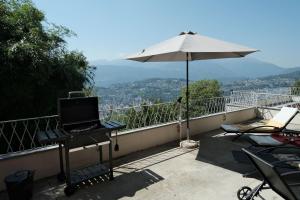 a laptop on a table on a balcony with an umbrella at Casa-Cleo in Lugano