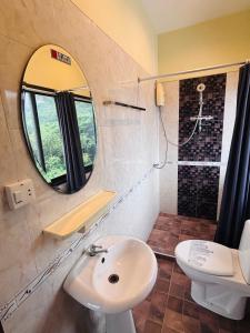 a bathroom with a sink and a mirror and a toilet at Jura 88 Guesthouse in Hua Hin