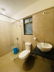 ein Badezimmer mit Toilette, Waschbecken und Dusche in der Unterkunft Petal Stays - Viman Nagar 