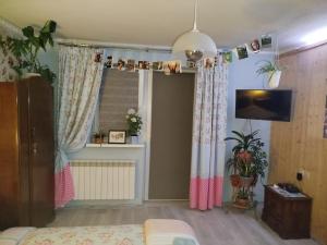 a bedroom with pink and white curtains and a window at Retro apartament Lukas in Ostrowsko