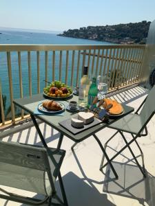 a table with a plate of food on a balcony at Cozy Studio - Vue Mer Magnifique in Roquebrune-Cap-Martin