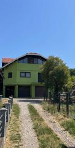 a green building with a road in front of it at PANONSKA JEZERA Zelena Oaza in Tuzla